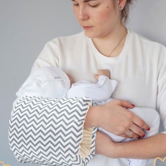 maman tient bebe avec coussin d allaitement brassard chevrons