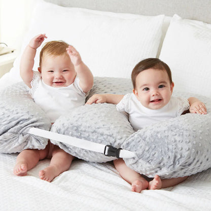 2 bebes assis dans coussin d allaitement twincuddle gris