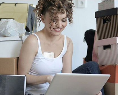 femme utilise tire-lait portable mamflow travaillant sur ordinateur