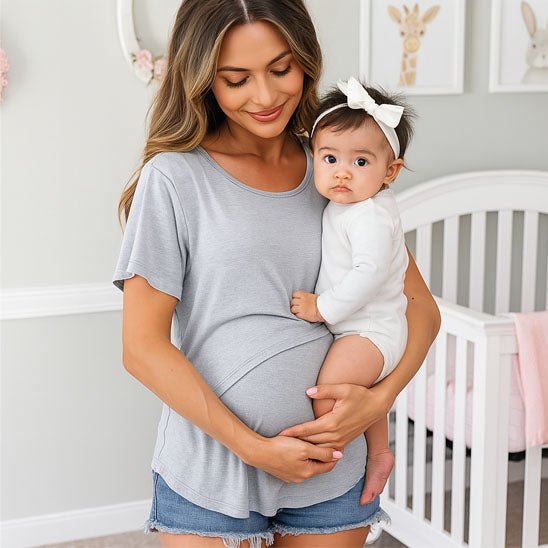 maman enceinte porte T shirt d'allaitement tenant bébé dans les bras