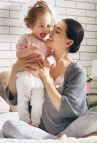 maman utilise tire lait main libre milkease double jouant avec sa fille