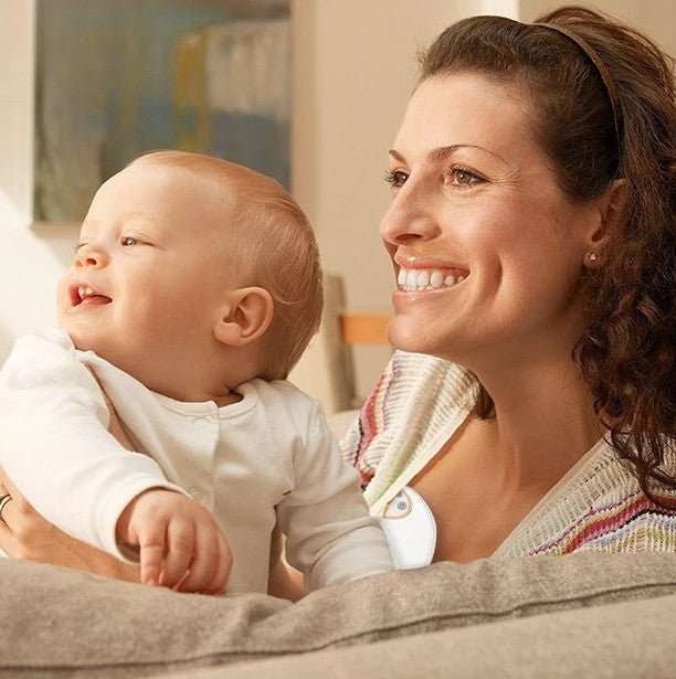 maman utilise Tire lait mains libres tenant bebe dans sofa