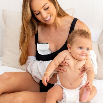 maman utilise Tire-lait portable MamaNova tenant bébé