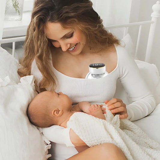 maman utilise tire lait portable mamelia tenant bebe dans les bras
